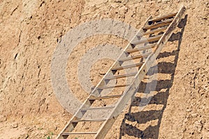 Wooden staircase attached to a clay rock on a sunny day