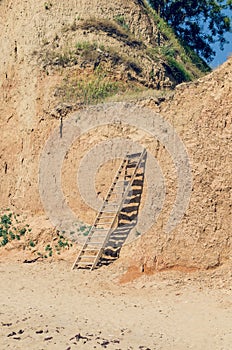 Wooden staircase attached to a clay rock on a sunny day