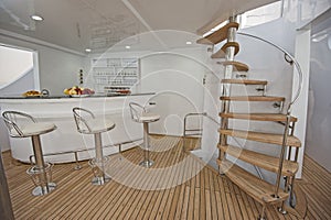 Wooden staircase and bar on sundeck of luxury yacht