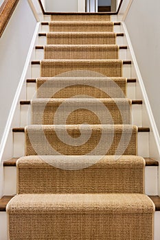 Wooden staircase with carpet runner photo