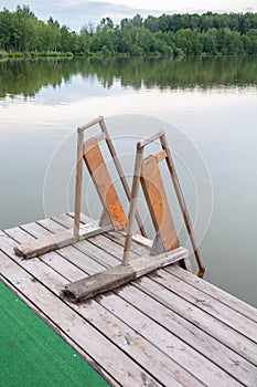 Wooden staircase with railings for descending into the water pond or lake. Rest in an eco hotel