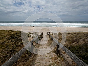 Wooden stairs leading to pacific ocean white sand beach Whiritoa in Hauraki Coromandel Peninsula Waikato New Zealand