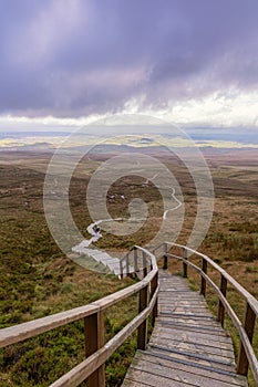 Wooden stairs on a trail through beautiful countryside up a mountain. Cuilcagh Boardwalk Trail in Fermanagh