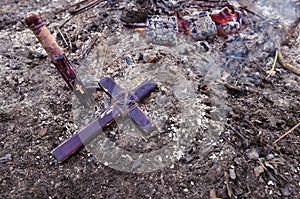 Wooden stake and cross lying on the ashes