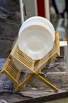 Wooden stand with clean white plates in the kitchen