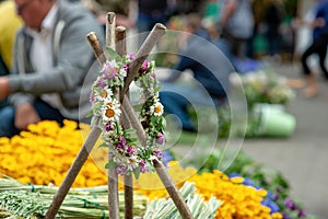 Wooden stand with the flowers braided crown. The Latvian Ligo ho