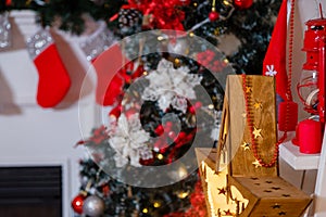 Wooden star toy. Red stockings hanging on fireplace with fir branches. Merry Christmas, Happy New Year and winter holidays