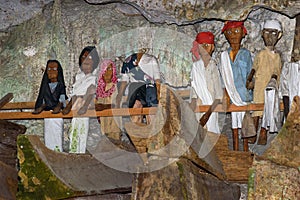 Wooden statues of Tau Tau and coffins in TampangAllo burial cave at Tana Toraja. Indonesia