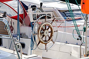 wooden steering wheel on yacht. sailboat rudder. Ropes, carbines and steering wheel of sea vessel.