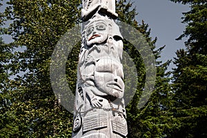 wooden stele with carved motives from the culture of the Tlingit at the Glacier Bay in Alaska photo
