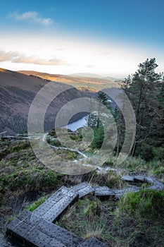 Wooden steps of a boardwalk on the top of a mountain with a view on Glendalough lakes, Wicklow Mountains