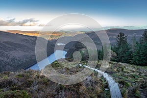 Wooden steps of a boardwalk on the top of a mountain with a view on Glendalough lakes, Wicklow Mountains