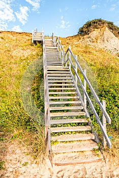 Wooden steps heading up to hill on seaside beach and sand dunes at Lowestoft Suffolk