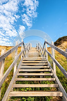 Wooden steps heading up to hill on seaside beach and sand dunes at Lowestoft Suffolk