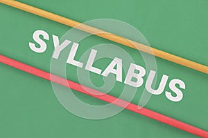 Wooden sticks over green background written with text SYLLABUS photo