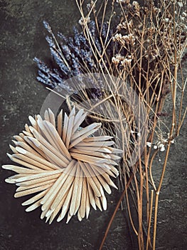 Wooden sticks, a tool for manicure on a background of flowers. Nail salon.