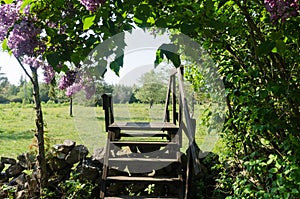 Wooden stile crossing a dry stone wall in a rural landscape by springtime