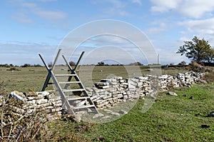 Wooden stile crossing an old dry stone wall