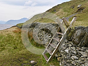 Wooden stile over stone wall