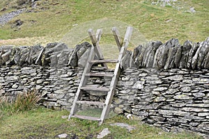Wooden stile over stone wall