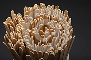 Wooden stirrers for coffee, tea and drinks in mug on a black background