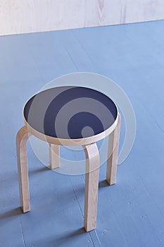 Wooden stool on an empty room. Blue floor