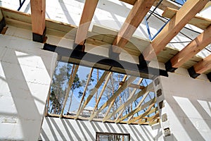 The wooden structure of the building. Installation of wooden beams at construction the roof truss system of the house.