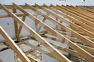 The wooden structure of the building. Wooden frame building. Wooden roof construction. Installation of wooden beams