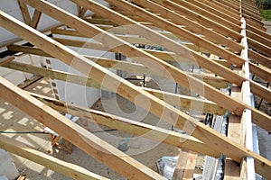 The wooden structure of the building. Wooden frame building. Wooden roof construction. Installation of wooden beams