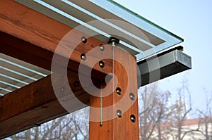 Wooden structure of the bus stop, the shelter of the gazebo pergola. the roof and walls are lined with glass. the glass is anchore