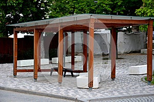 Wooden structure of the bus stop, the shelter of the gazebo pergola. the roof and walls are lined with glass. the glass is anchore