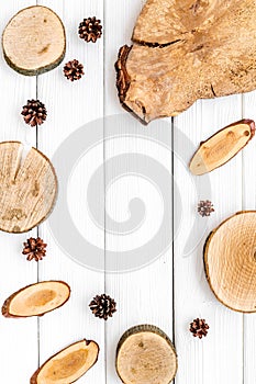 Wooden stumps, immortelle and pine cones frame for blog background top view space for text