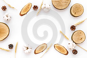 Wooden stumps, immortelle and pine cones frame for blog background top view space for text