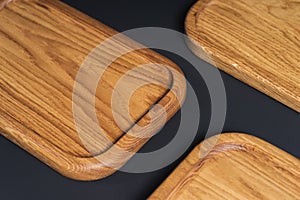 Wooden stylish cutting boards for the kitchen on a black background.