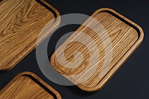 Wooden stylish cutting boards for the kitchen on a black background.