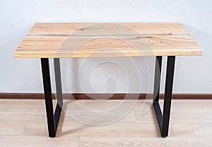 Wooden stylish table made of solid wood with epoxy resin on the background of the floor and wall. overall plan