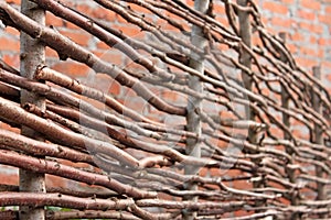 Wooden stylized horizontal fence and red brick wall as a defocused pattern