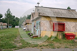 Wooden summer tourist lodge with a board with fire prevention means at the Iskra camp site in the village of Shushenskoye.