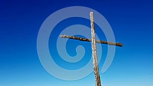 Wooden summit cross with blue sky. Close up, copy space.