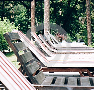 Wooden sun loungers by the swimming pool on a summer day