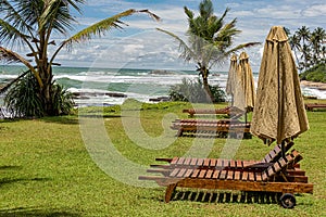 Wooden sun lounges and parasols set out awaiting the tourists