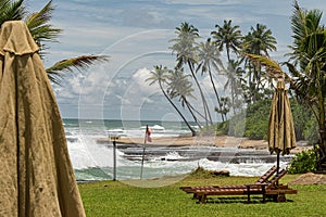 Wooden sun lounges and parasols set out awaiting the tourists