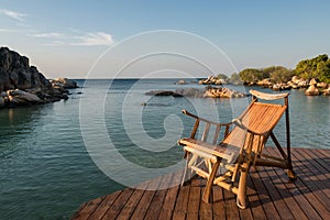 Wooden sunbed at resort patio by sea in morning, Ko Man Klang