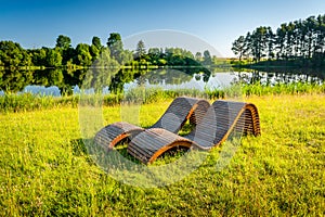 Wooden sunbeds on the grass in the park.