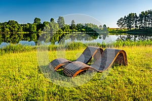 Wooden sunbeds on the grass in the park.