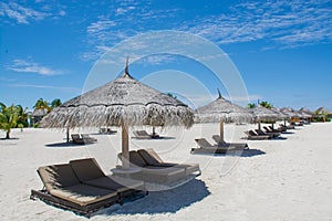 Wooden sunbeds on the tropical beach at Maldives