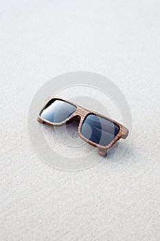 Wooden sunglasses lying on the sand