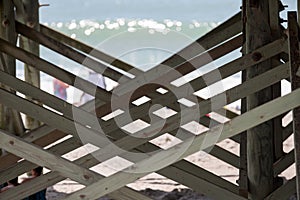 Wooden support cross planks under the fishing pier boardwalk