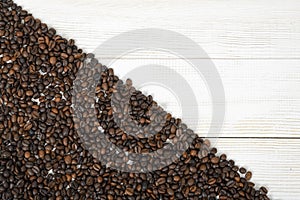 Wooden surface half backfilled with coffee beans
