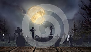 Wooden surface and moonlit graveyard with old creepy headstones on Halloween